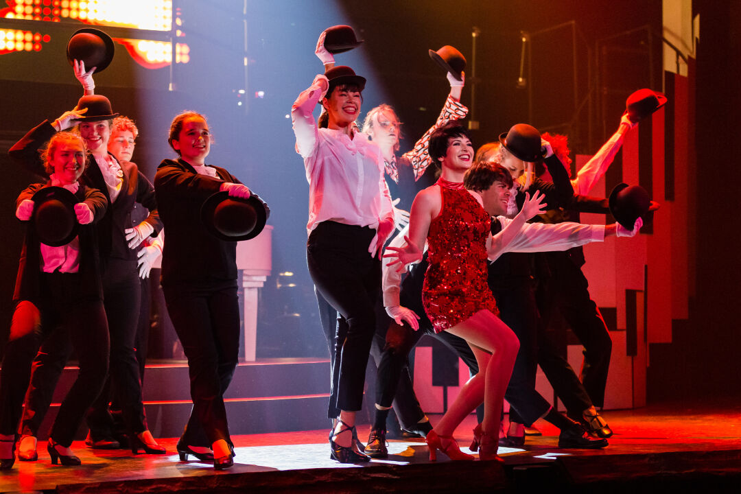 Actor portraying Liza Minnelli with a group of dancers performing a song in The Boy from Oz musical.