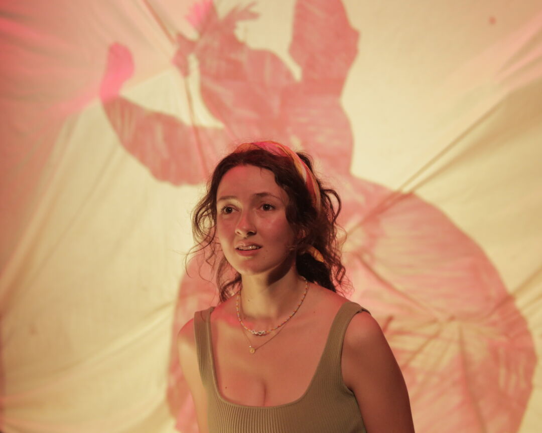 Young female ensemble member with a concerned expression, mid-performance