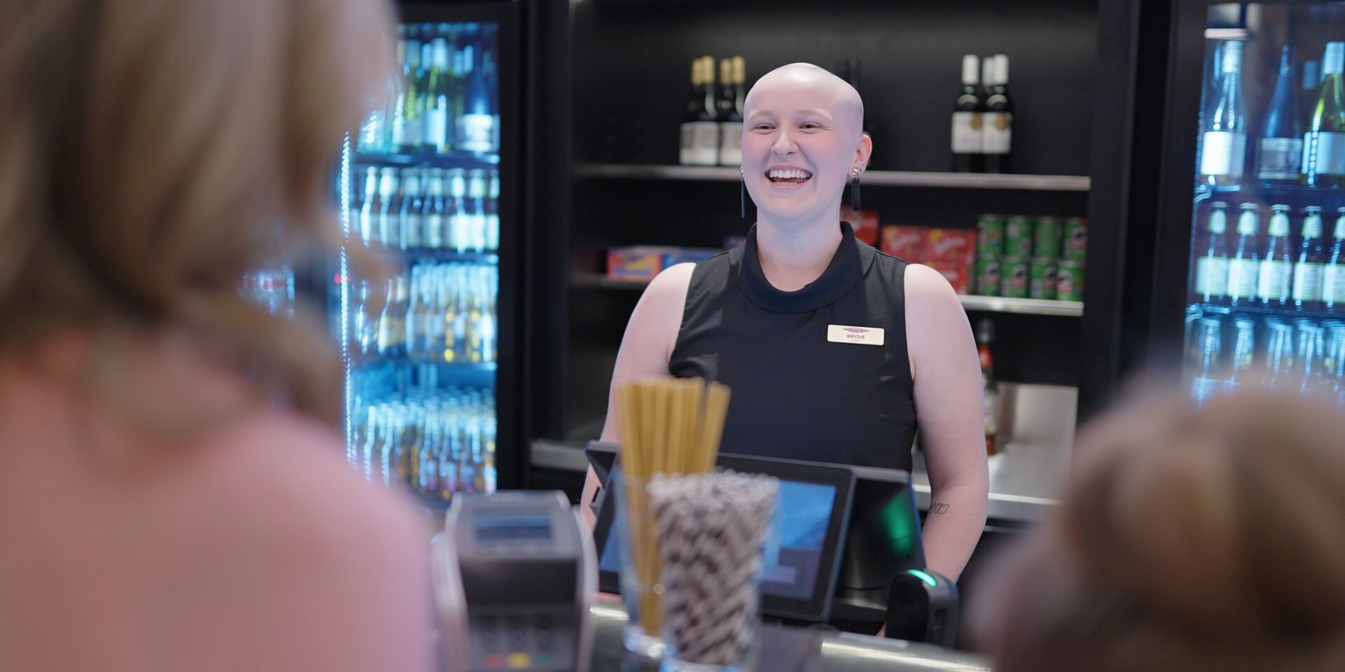 Bar staff greeting customers. 