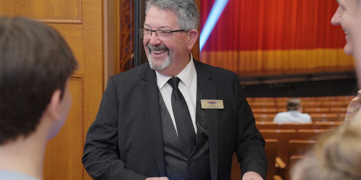 Smiling usher scanning patrons' tickets